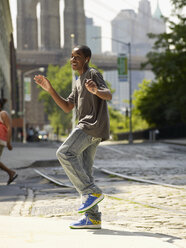 Afrikanischer Junge tanzt zu Musik in städtischer Umgebung - BLEF00043