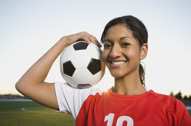 Gemischtrassige Frau posiert mit Fußball - BLEF00066