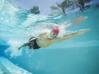 Gemischtrassiger Mann schwimmt im Schwimmbad - BLEF00095