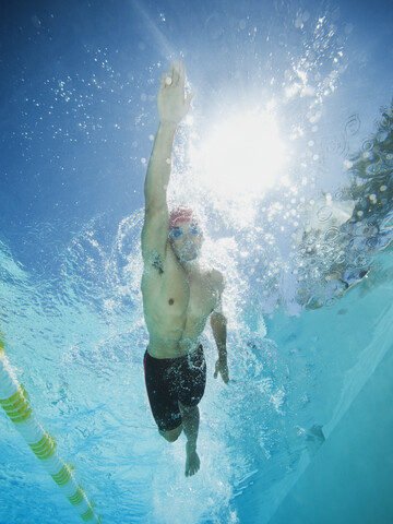 Gemischtrassiger Mann schwimmt im Schwimmbad, lizenzfreies Stockfoto