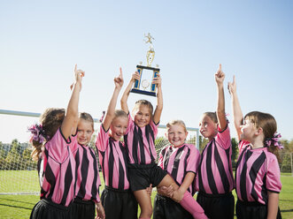 Jubelnde Fußballspielerinnen posieren mit dem Pokal - BLEF00104