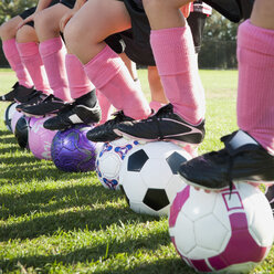 Fußballspielerinnen stehen mit den Füßen auf Fußbällen - BLEF00105