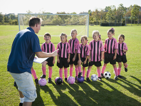 Trainer motiviert Mädchenfußballerinnen, lizenzfreies Stockfoto