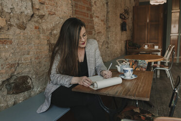 Young woman taking notes in a cafe - AHSF00121