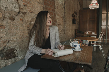 Young woman taking notes in a cafe - AHSF00122