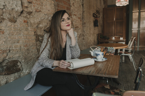 Young woman taking notes in a cafe stock photo