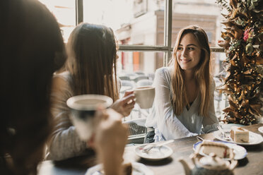 Three happy young women meeting in a cafe - AHSF00137