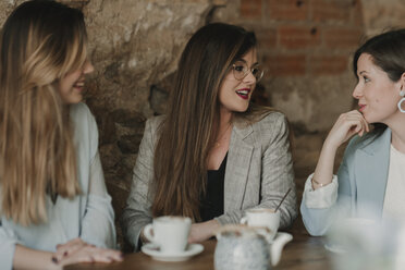 Three happy young women meeting in a cafe - AHSF00142