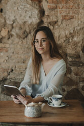 Porträt einer jungen Frau, die in einem Café ein Tablet benutzt - AHSF00152