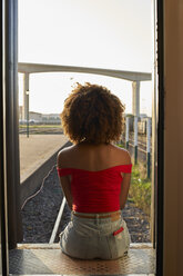 Woman sitting at the back door of a train looking out - VEGF00063