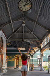 Happy woman under the clock at the train station - VEGF00070