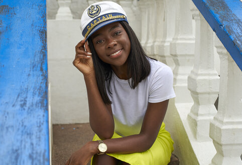 Porträt einer lächelnden jungen Frau mit Kapitänsmütze - VEGF00087