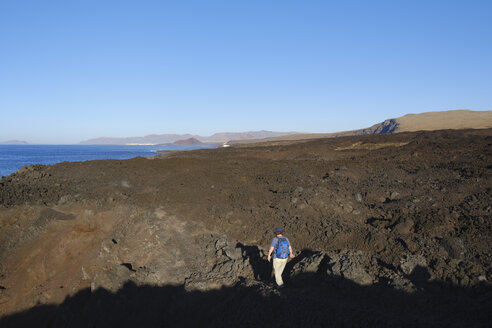 Spain, Canary Islands, Lanzarote, Tinajo, Los Volcanos nature park, women hiking through lava waste - SIEF08597