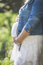 Pregnant woman holding her belly, close up - ASCF00996