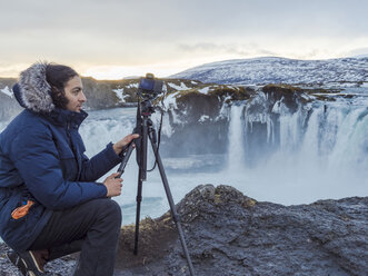 Iceland, photographer at Godafoss Waterfall in winter - TAMF01304