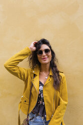 Portrait of young woman wearing yellow leather jacket and sun glasses - MGIF00411