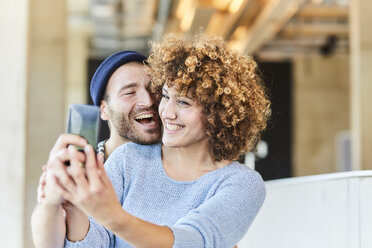 Laughing couple taking a selfie - FMKF05616