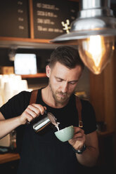 Barista bei der Zubereitung eines Kaffees in einem Kaffeehaus - OCMF00422