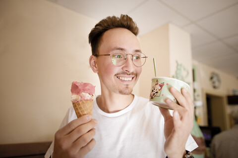 Porträt eines jungen Mannes mit Eiscreme in einer Eisdiele, lizenzfreies Stockfoto