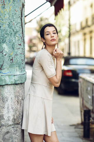 Porträt einer modischen jungen Frau in einem Kleid in der Stadt, lizenzfreies Stockfoto