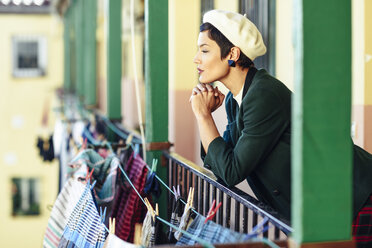 Fashionable young woman on porch of an apartment building - JSMF00991