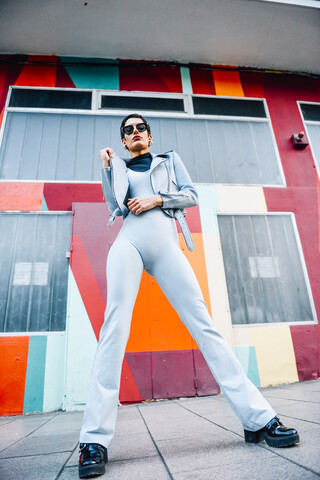 Fashionable young woman posing with colorful urban background stock photo