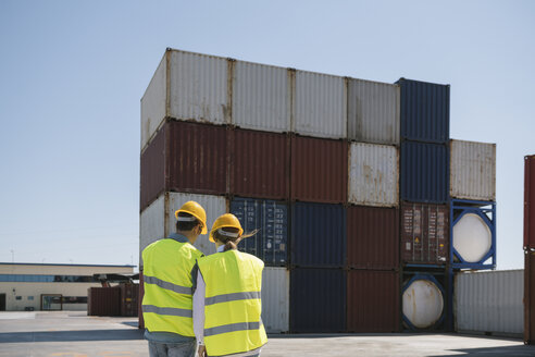 Arbeiter vor Frachtcontainern auf einem Industriegelände - AHSF00178