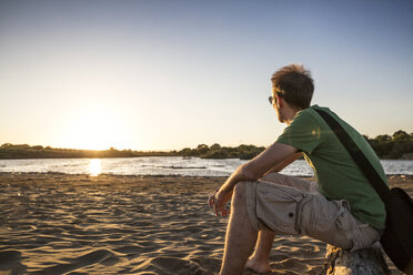 Italy, Sicily, young man enyoing the sunset at the beach of Eloro - MAMF00589