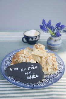 Teller mit Butterkuchenstücken und einem handgeschriebenen Spruch auf einer Schiefertafel - GISF00422