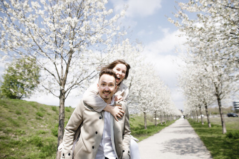 Zärtliches Paar hat Spaß in einem Park im Frühling, lizenzfreies Stockfoto