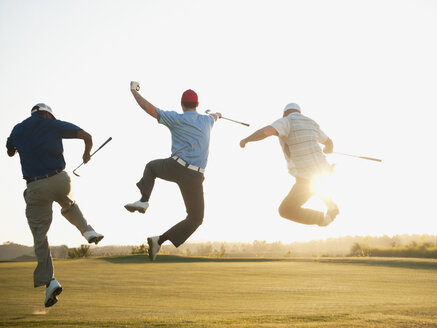 Aufgeregte Golfer springen in der Luft auf dem Golfplatz - BLEF00134