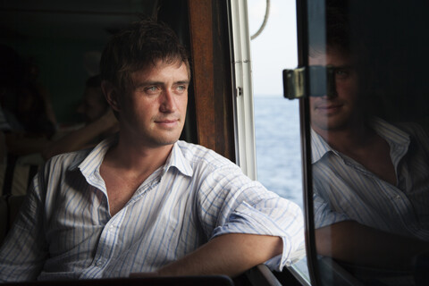 Kaukasischer Mann fährt in einem Boot, lizenzfreies Stockfoto