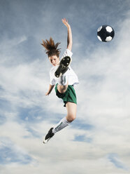 Caucasian teenager kicking soccer ball in mid-air - BLEF00155