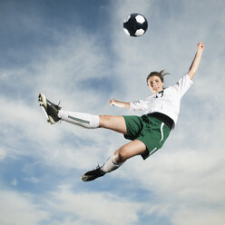 Caucasian teenager kicking soccer ball in mid-air - BLEF00156