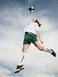 Caucasian teenager heading soccer ball in mid-air - BLEF00157