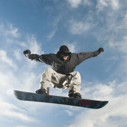 Kaukasischer Mann auf Snowboard in der Luft - BLEF00158
