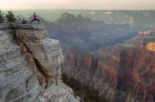 Caucasian woman practicing yoga on cliff near canyon - BLEF00165