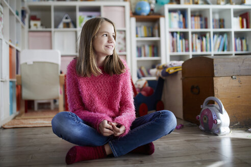 Confident girl sitting cross-legged on floor of her room - RBF07015