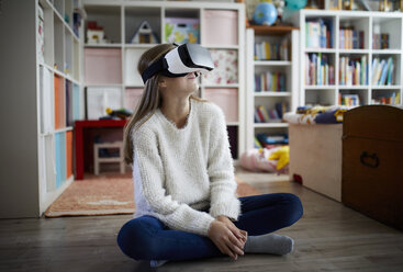 Mädchen sitzt in ihrem Zimmer und benutzt eine VR-Brille - RBF07024
