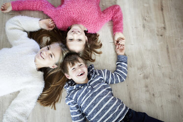 Happy siblings lying on the floor, laughing - RBF07025