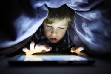 Little boy playing secretly with his digital tablet, hidden uunder blanket - RBF07029