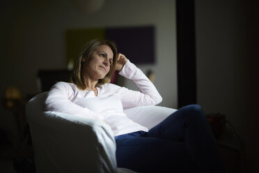 Woman sitting at home, relaxing in arm chair - RBF07033