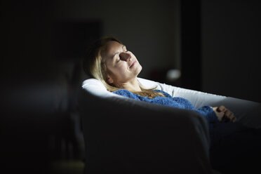Woman sitting at home, relaxing in arm chair - RBF07040