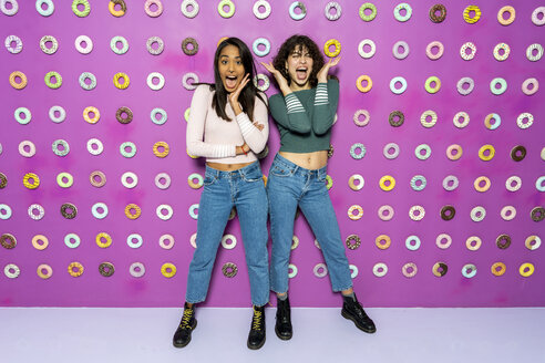 Two young women screaming at an indoor theme park with donuts at the wall - AFVF02818