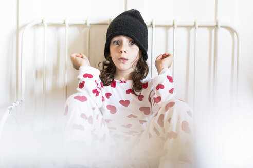Porträt eines kleinen Mädchens mit Mütze und Pyjama im Bett sitzend - ERRF01190