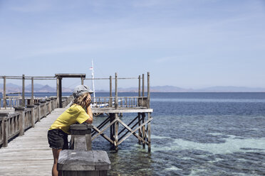 Indonesien, Komodo-Nationalpark, Mädchen auf einem Steg mit Blick nach draußen - MCF00130