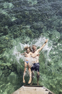 Indonesien, Komodo-Nationalpark, Vater und Tochter springen ins Meer - MCF00141