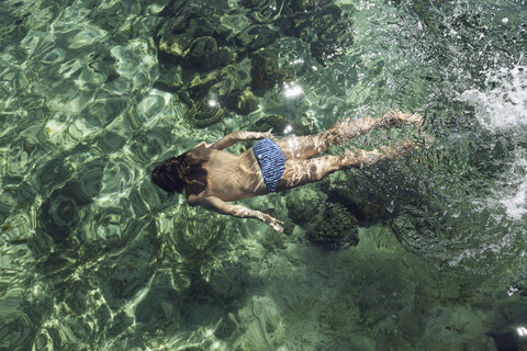 Indonesien, Komodo-Nationalpark, Mädchen schwimmt im Meer, lizenzfreies Stockfoto