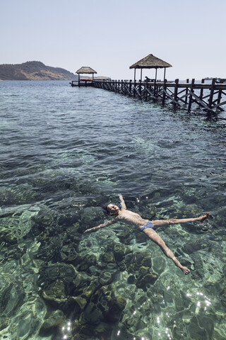 Indonesien, Komodo-Nationalpark, Mädchen schwimmt im Meer, lizenzfreies Stockfoto