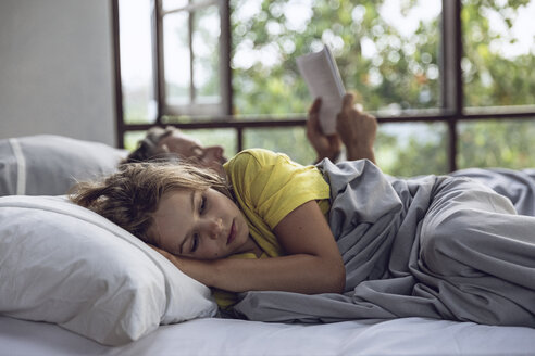 Mädchen liegt mit Vater im Bett und liest ein Buch - MCF00149